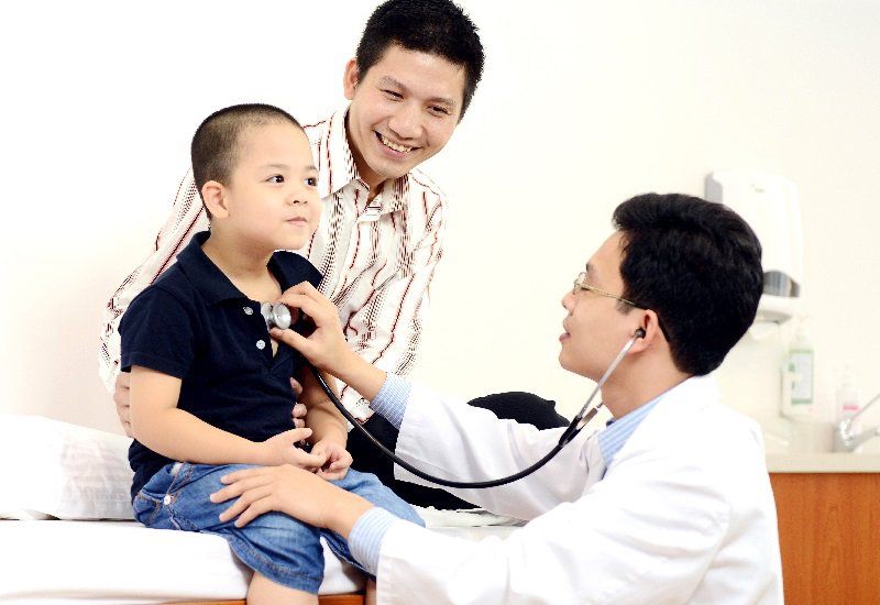 Trẻ được bác sĩ khám sàng lọc trước khi tiêm phòng