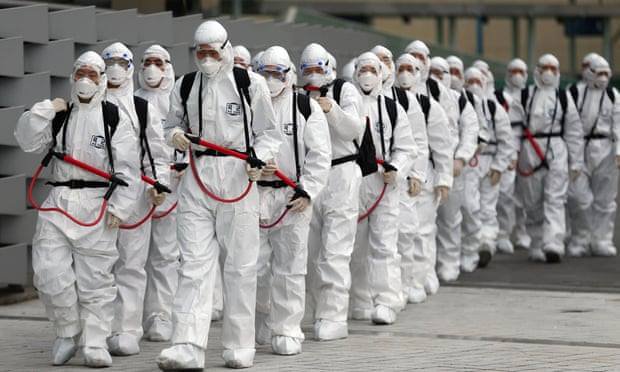 Binh lính Hàn Quốc mặt đồ bảo hộ đi phun thuốc khử trùng tại Daegu