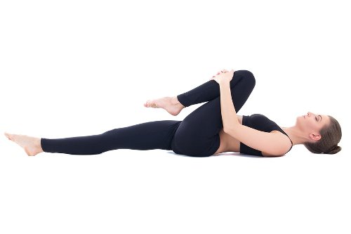 Tập giãn cơ trước khi ngủ với bài kéo đầu gối lên ngực
