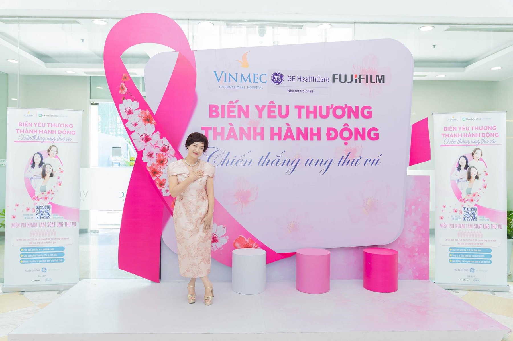 Tại chiến dịch PinkWin, NSND Lê Khanh xuất hiện tinh tế với chiếc đầm hồng sang trọng và tone-sur-tone với màu của chiếc nơ hồng, biểu tượng cho niềm hy vọng, sức mạnh và sự đồng lòng chống ung thư vú