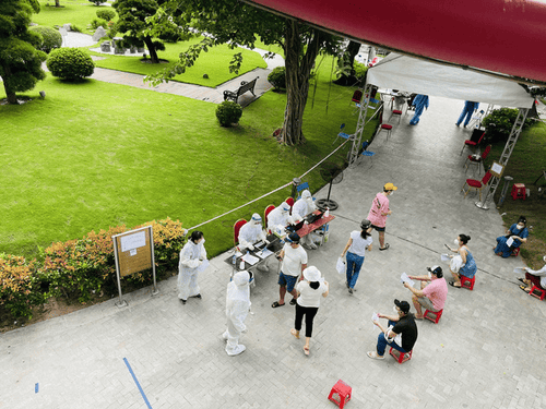 People strictly follow social distancing regulations and are supported and guided by medical staff.