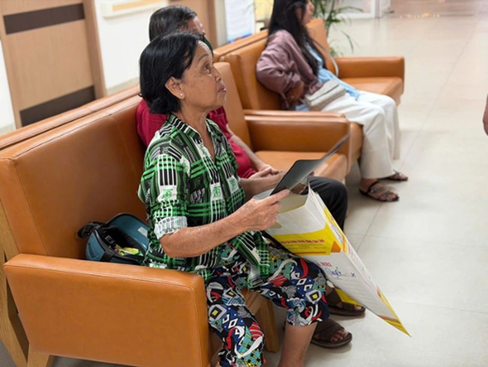 Bà Huỳnh Thị Tuyết cầm trên tay hồ sơ bệnh án cũ chờ được thăm khám