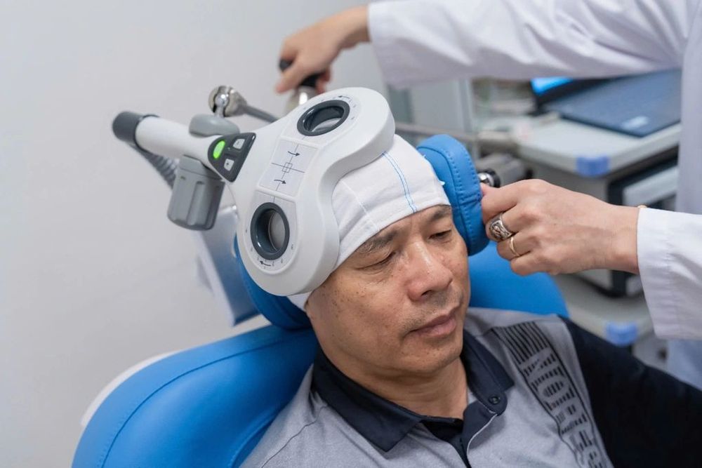 Chú Tuyến đang được thực hiện kích thích từ trường xuyên sọ TMS trong một buổi tái khám
