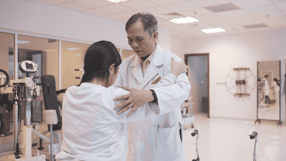 M. chập chững tập đi dưới sự hướng dẫn của bác sĩ phục hồi chức năng