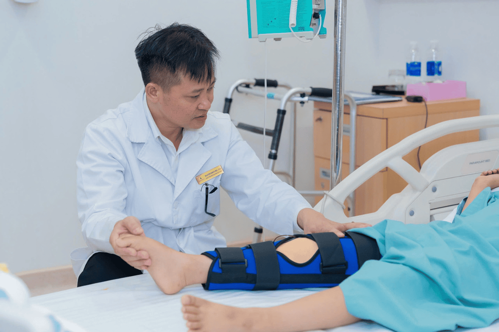 BSCKII Nguyễn Văn Vĩ ân cần hỗ trợ bệnh nhân tập phục hồi chân