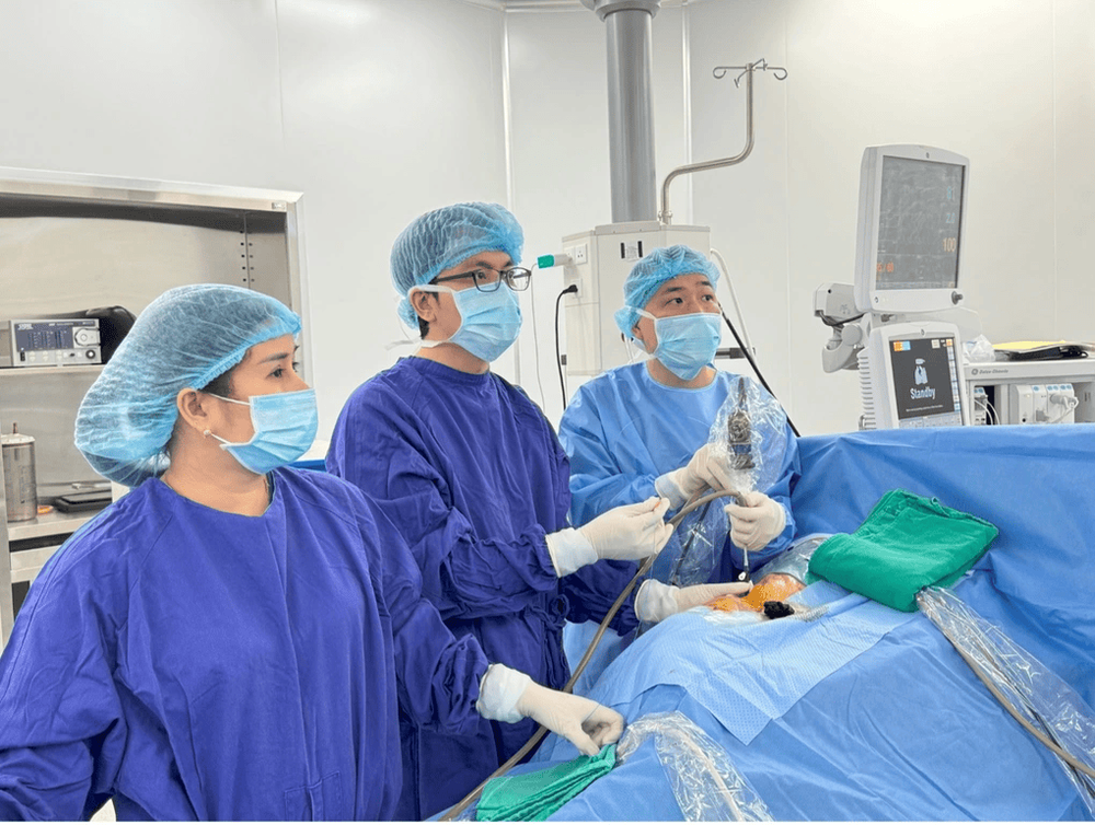 BS.CKII Đặng Xuân Tùng, bác sĩ Tiết niệu, Khoa Ngoại tiêu hóa - Gan mật - Tiết niệu (ngoài cùng bên phải), cùng ê-kíp tiến hành nội soi tán sỏi thận qua da đường hầm nhỏ (Mini PCNL) cho bệnh nhân