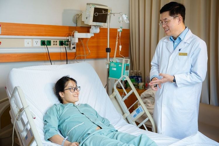 Hình ảnh bác sĩ Lê Văn Thành và chị Dương Thị Mến trò chuyện vui vẻ sau ca ghép gan thành công