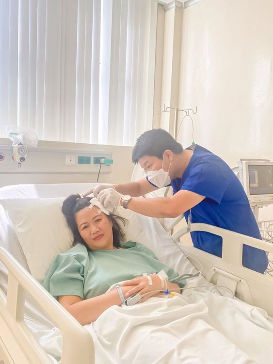 Dr. Hoang Nguyen Nhat Tan examines a patient receiving treatment in the ICU (Intensive Care Unit).