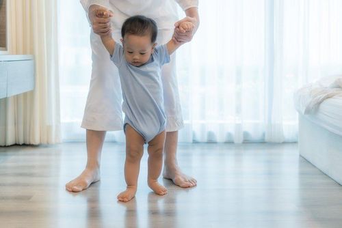 Dạy bé tập đi đi trên sàn nhà và không mang giày